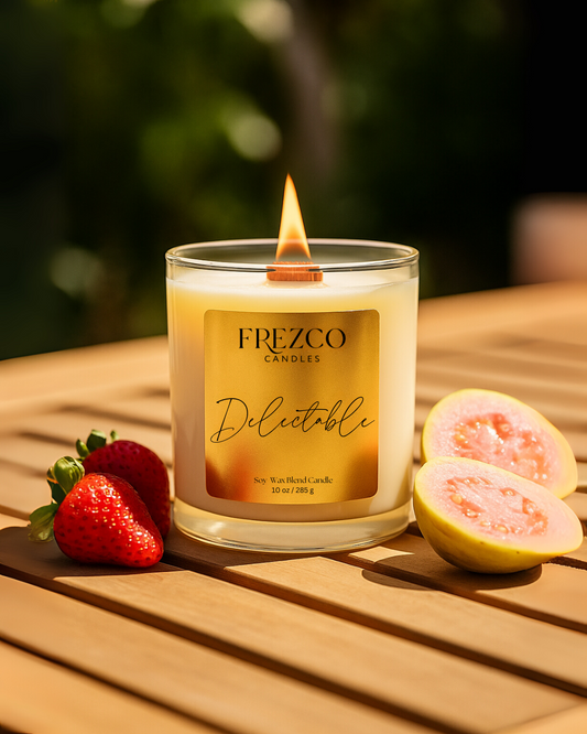 Frezco Candles Delicatable candle on a wooden surface with strawberries and a guava.
