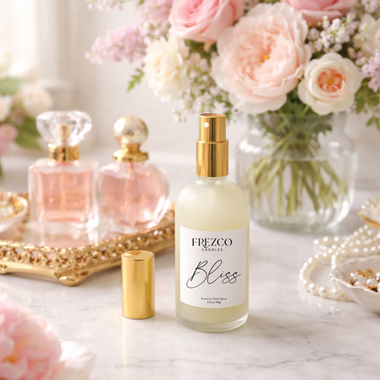 Frezco Bliss perfume bottle on a marble surface with flowers and jewelry in the background