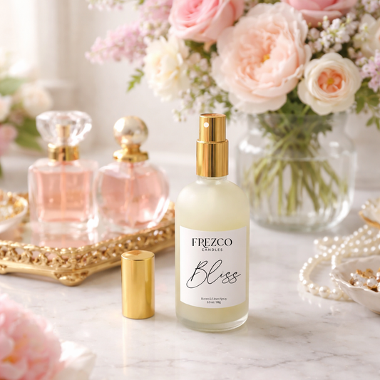 Frezco Bliss perfume bottle on a marble surface with flowers and jewelry in the background