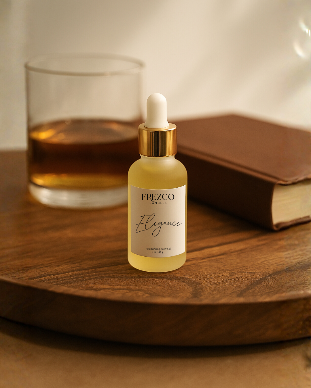 Frezco Elegance skincare serum bottle on a wooden surface with a glass and book in the background