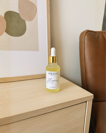 Frezco Elegance skincare serum bottle on a wooden surface with a blurred abstract painting in the background.