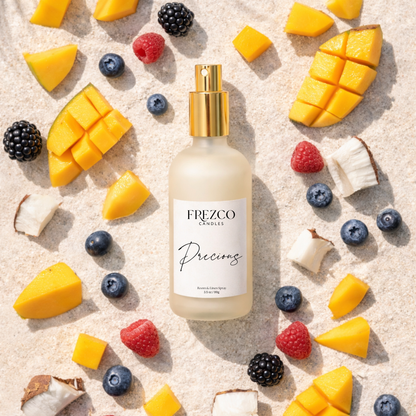 Frezco candles bottle surrounded by sliced mangoes, berries, and coconuts on a sandy background