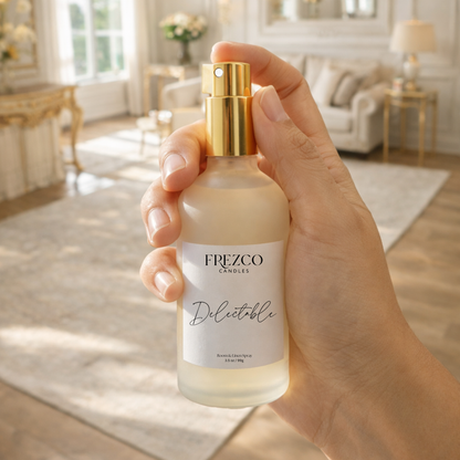 Hand holding a Frezco Candles Delectable  spray bottle in a bright living room.