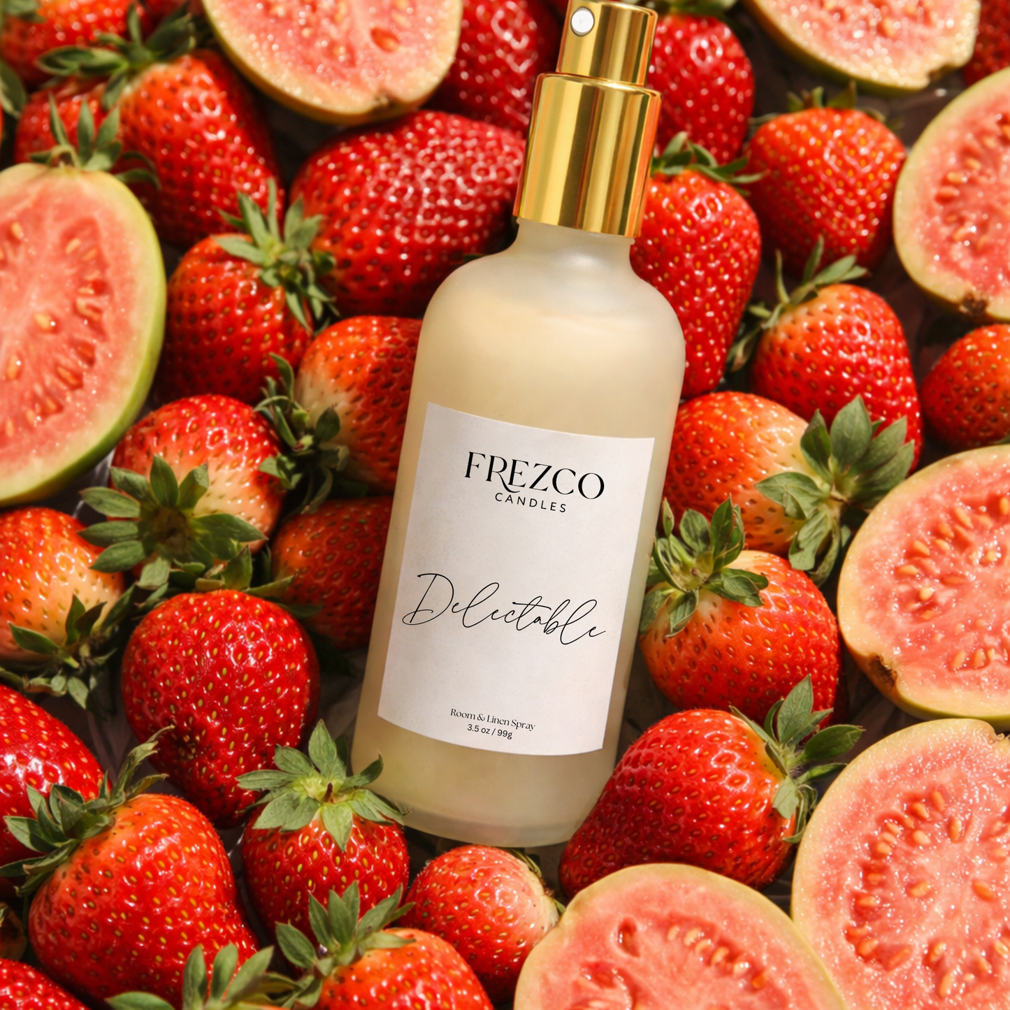 Frezco Candles Delectable spray bottle on a background of strawberries and guava slices